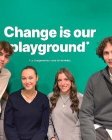 Deux étudiantes et deux étudiants posent devant un fond vert surlequel est écrit en blanc la devise de l'ISEG : Change is our Playground.